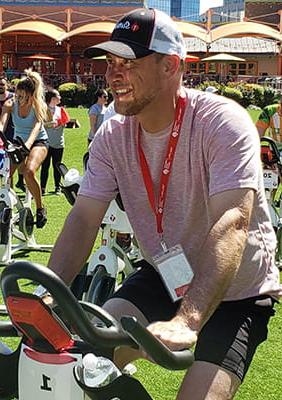 Jeffery Marquis riding a stationary bike at an outdoor event